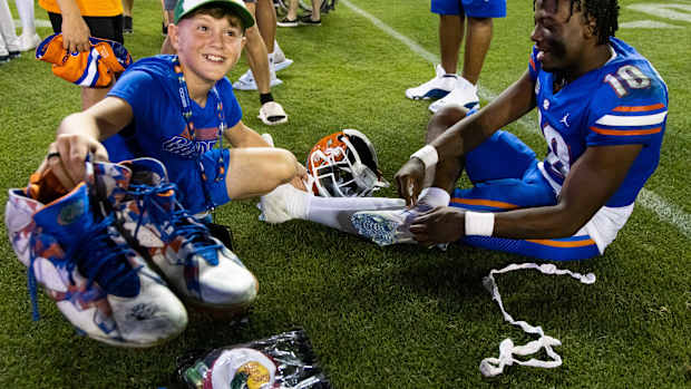 Florida Gators fan holds up autographed cleats.